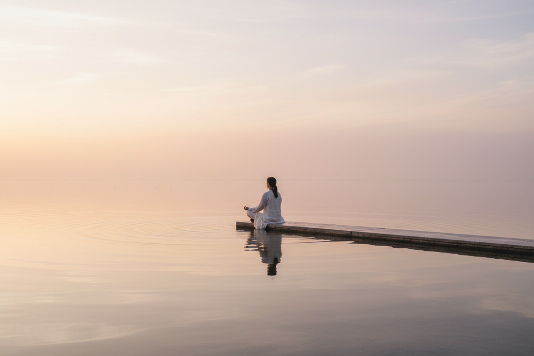 meditating woman on pier