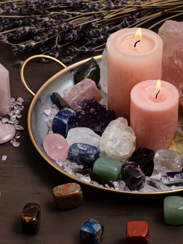 Crystals arranged around candles on a decorative plate for new arrivals.