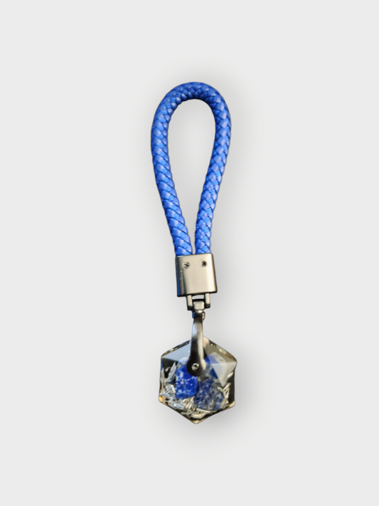 Blue woven keychain with a geometric pendant on a white background