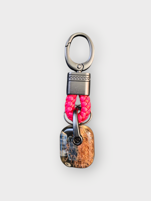 Keychain with pink beads and metallic accents on a white background