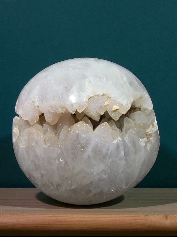 A stunning clear quartz sphere featuring a natural sugar-druzy opening