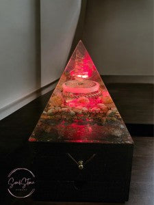 Soul Stone Designs pyramid orgonite lamp with copper, crystals, and wooden base, emitting a calming red glow.