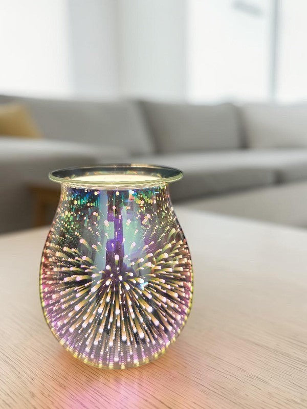 SoulStone Designs 3D fireworks electric wax warmer with iridescent glass finish glowing on a wooden table.