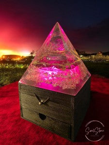 SoulStone Designs orgonite pyramid lamp with Metatron's Cube and crystals, glowing pink on a wooden box base.