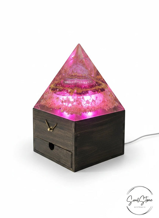 SoulStone Designs pink orgonite pyramid lamp with Metatron's Cube and Flower of Life, on wooden box base with LED light.