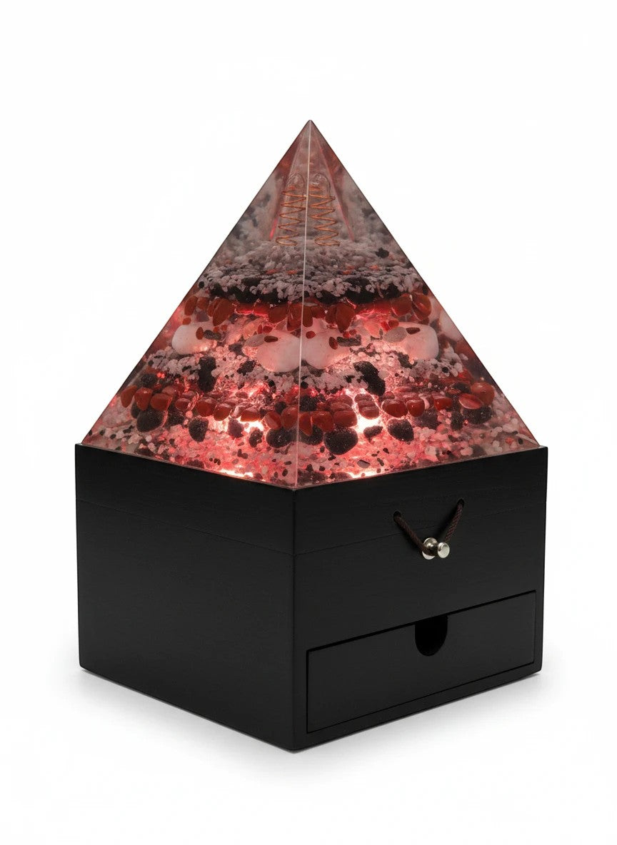 Soul Stone Designs Aegis Root orgonite pyramid lamp with red jasper, black obsidian, and clear quartz. Features a copper coil and a black wooden base with a drawer.