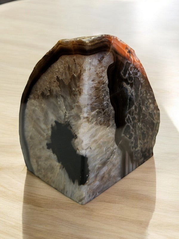 Soul Stone Designs natural agate geode bookend with intricate banding in earthy tones of brown, white, and orange.