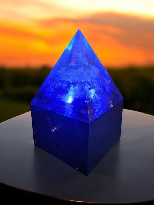 Soul Stone Designs blue orgonite pyramid lamp with internal crystals and wooden box base, glowing with blue light.