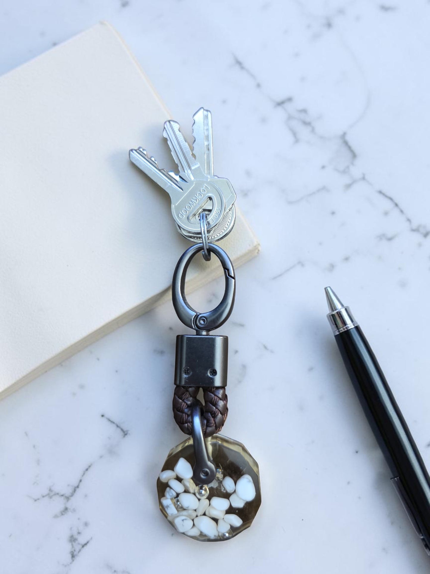 Soul Stone Designs Howlite mini orgonite keychain with white stones embedded in resin, attached to keys.
