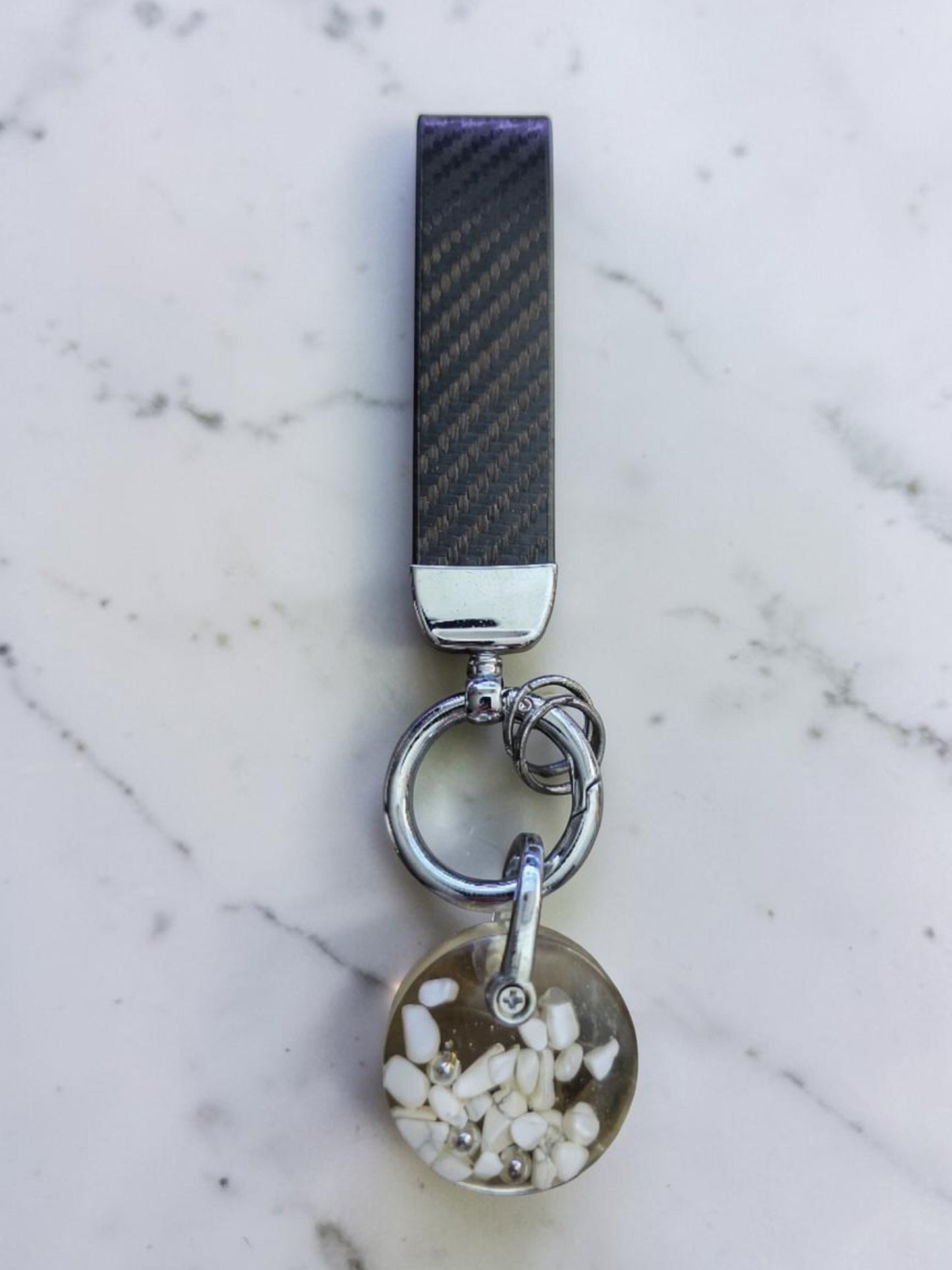 Soul Stone Designs Howlite mini orgonite keychain with white stones and silver shavings in clear resin. Carbon fiber strap.