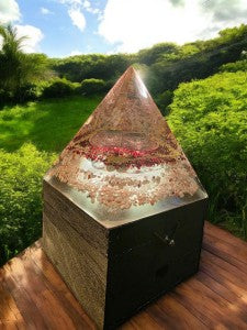 SoulStone Designs orgonite pyramid lamp with Metatron's Cube and crystals on wooden base, glowing softly.
