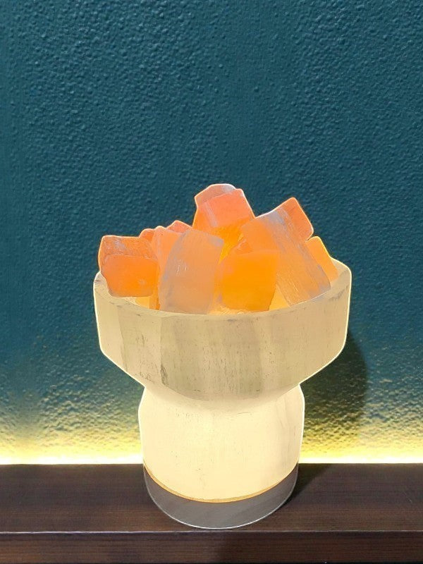Soul Stone Designs Selenite bowl lamp with peach selenite chunks, emitting a warm golden glow.