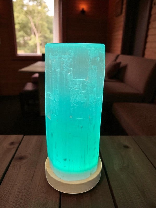 Soul Stone Designs natural selenite tower lamp with multicolour LED base, glowing teal.