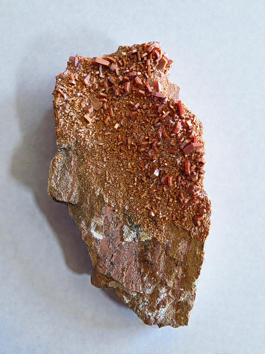 Vanadinite crystal cluster with vibrant red-orange hexagonal crystals on natural matrix